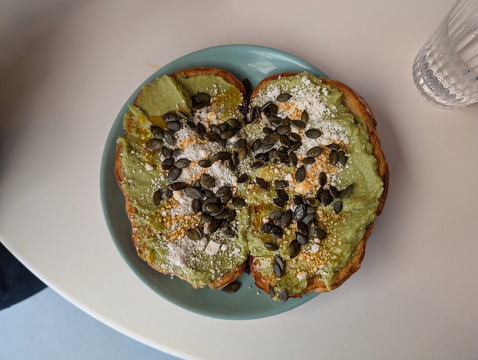 Avocado toast topped with seeds and crumbled cheese