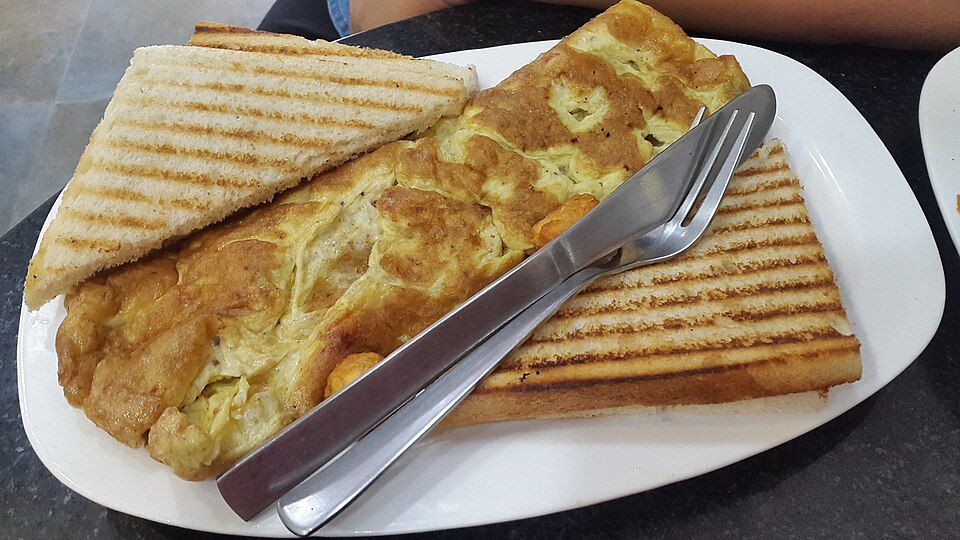 A golden masala omelette served with grilled toast